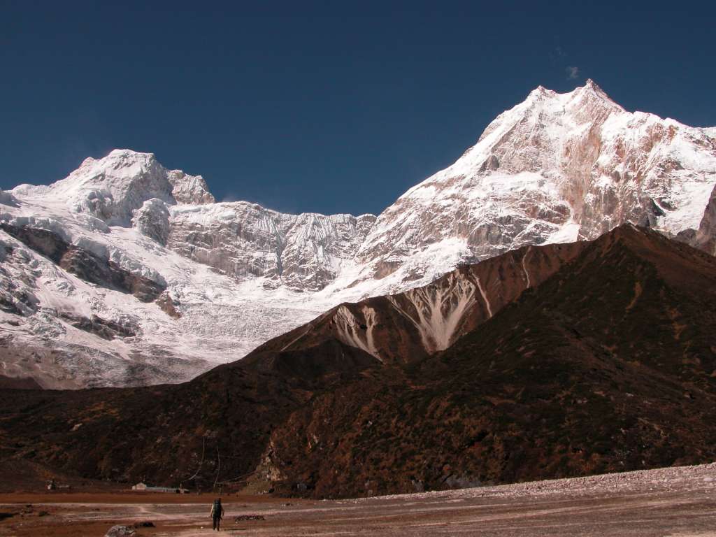 Manaslu 07 10 Ngadu Chuli and Manaslu From Pung-gyen Gompa The Pung-gyen gompa (3870m) is named after Manaslu, as Pung-gyen means bracelet, a good description of the two peaks. To the left is Ngadi Chuli (Peak 29) and to the right the main summit of Manaslu and the East Pinnacle. The Pung-gyen Gompa was destroyed by fire during the winter of 1953 after the first Japanese expedition to Manaslu, killing 18 inhabitants, mostly nuns. The villagers believed the god residing on Manaslu destroyed the gompa to show his wrath for the trespassers, and refused to let the second Japanese expedition to Manaslu climb the mountain in 1954. When I got there, there was nobody home. I wonder where all the monks are gone?